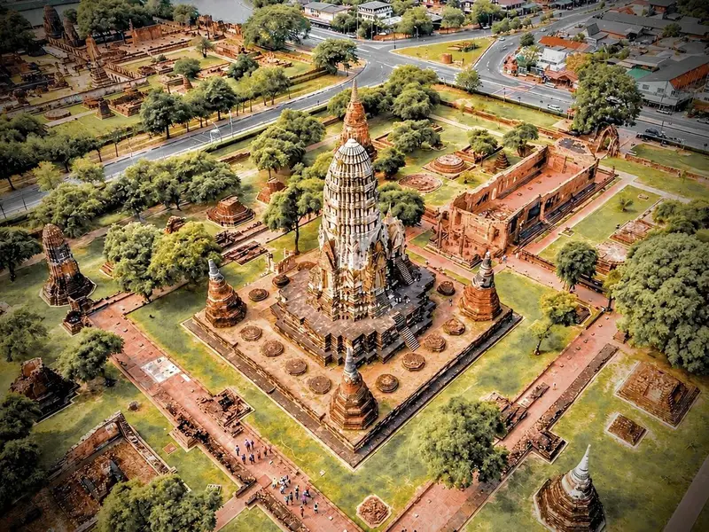 Ancient brick temple ruins and a Buddha statue at Wat Mahathat on an Ayutthaya day trip from Bangkok, Thailand